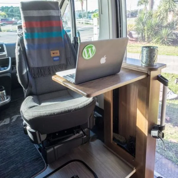 A laptop set up on a van desk in the cab 