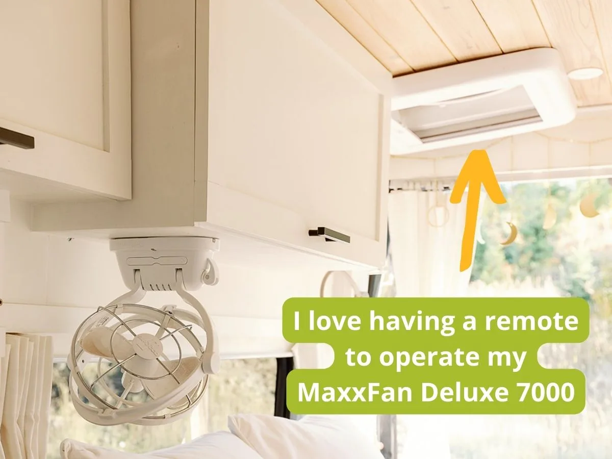 maxxair fan deluxe review Interior view of a camper van with the MaxxAir Fan Deluxe 7000 installed in the ceiling, highlighted by a yellow arrow, and overlaid text reading “I love having a remote to operate my MaxxFan Deluxe 7000.”