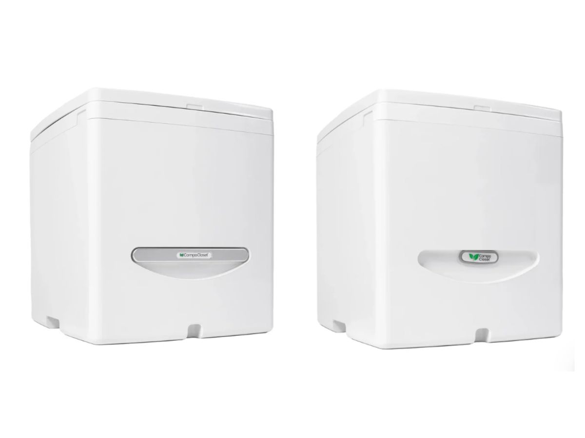 Two Compo Closet Cuddy composting toilets shown side-by-side from a front angle, displaying slight design variations in the base vent and logo placement. Used in a Trelino vs Cuddy Lite composting toilet review to compare model differences and exterior features. On the left is Cuddy Original, on the right is Cuddy Lite composting toilet. The primary difference between the two is the silver agitator arm on the front of the toilet which is only available on the Cuddy Original model.