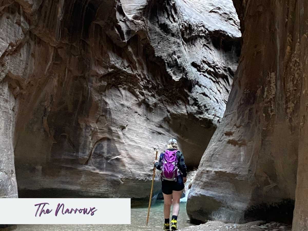 Hiker with a purple backpack uses a walking stick while wading through the Virgin River between towering sandstone walls in The Narrows at Zion National Park. Text on the image reads The Narrows, highlighting this iconic river hike often included in a Zion National Park itinerary for a unique slot canyon adventure.