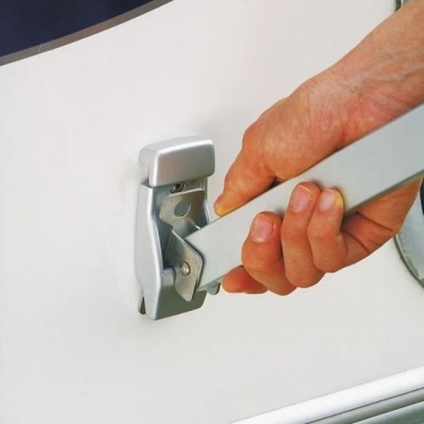 Hand gripping a metal support arm and securing it into a wall mounted bracket on the side of a camper van. Close up highlights the locking mechanism used when setting up a Fiamma F45S vs F80S awning support arm.